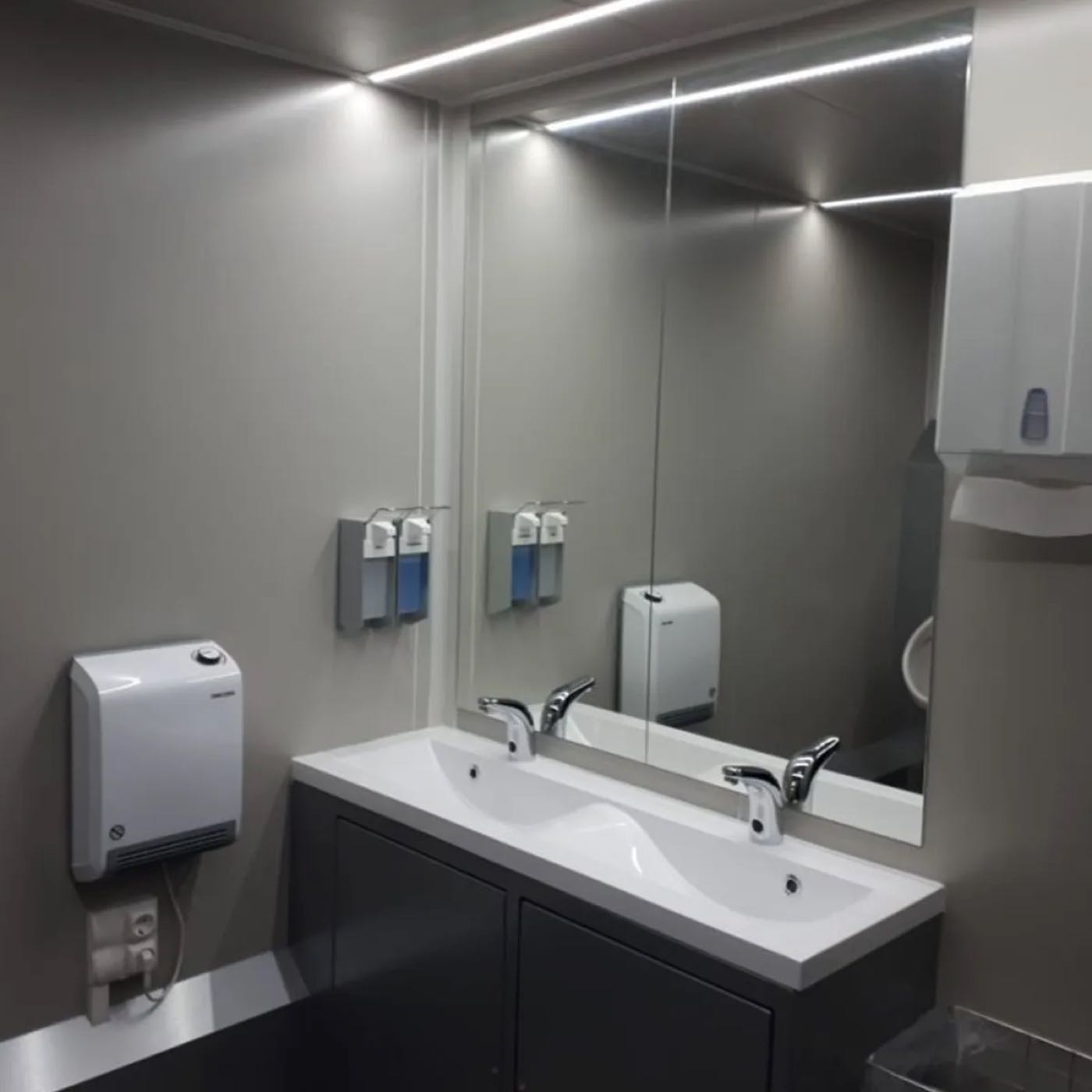 Waschbereich im Toilettenanhänger mit großem Spiegel, Armaturen und Handtuchspender