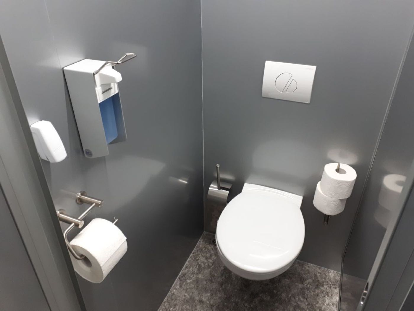 WC-Kabine mit Wand-WC, Papierhalter und Seifenspender